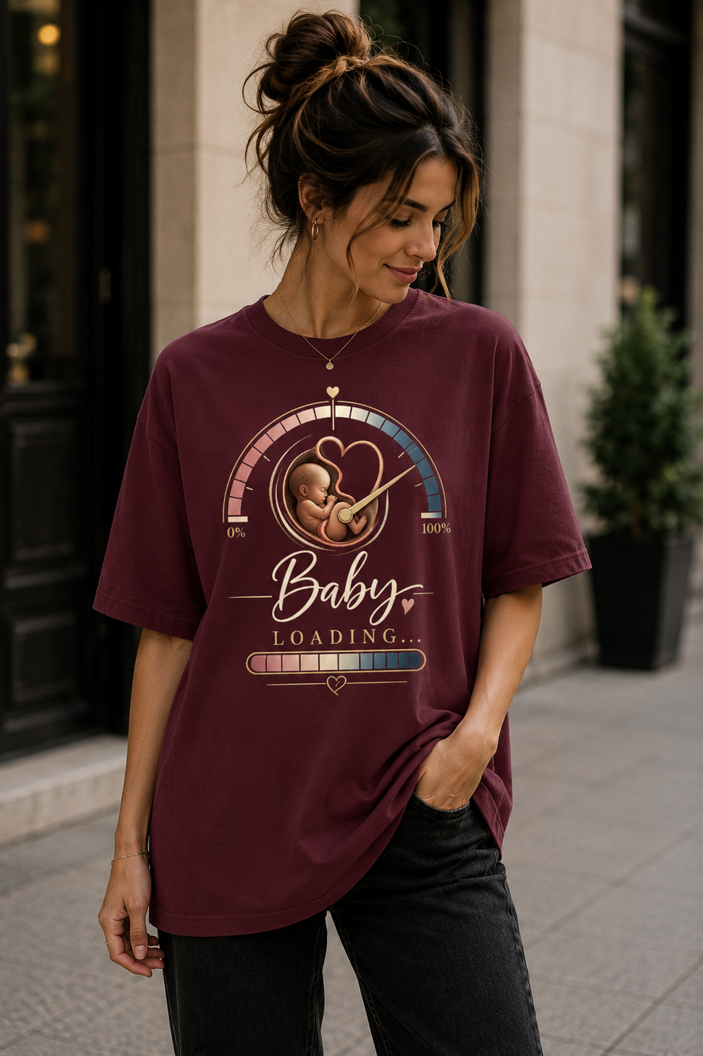 Burgundy women’s pregnancy announcement graphic T-shirt featuring a baby inside a heart-shaped progress gauge with Baby Loading text and a loading bar.