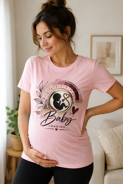 Pink women’s pregnancy announcement graphic T-shirt featuring a baby silhouette inside an artistic progress gauge with botanical details, burgundy and gold accents, and Baby Loading text.