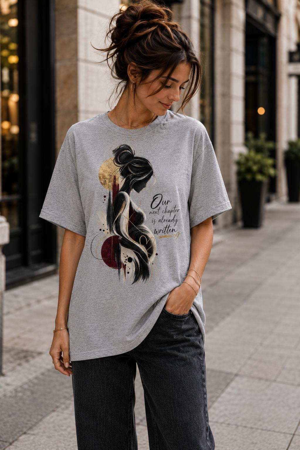 Grey women’s pregnancy announcement graphic T-shirt with an artistic expectant mother silhouette in black, burgundy and gold and the message Our next chapter is already written.