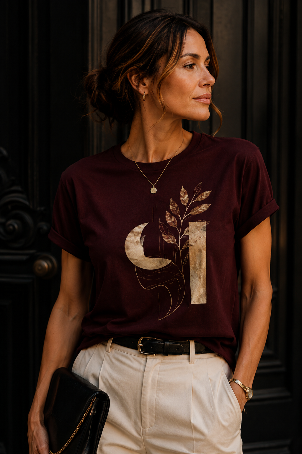 Woman wearing a crimson Moon & Flora artistic graphic T-shirt featuring a deep crimson moon, botanical elements and geometric details.