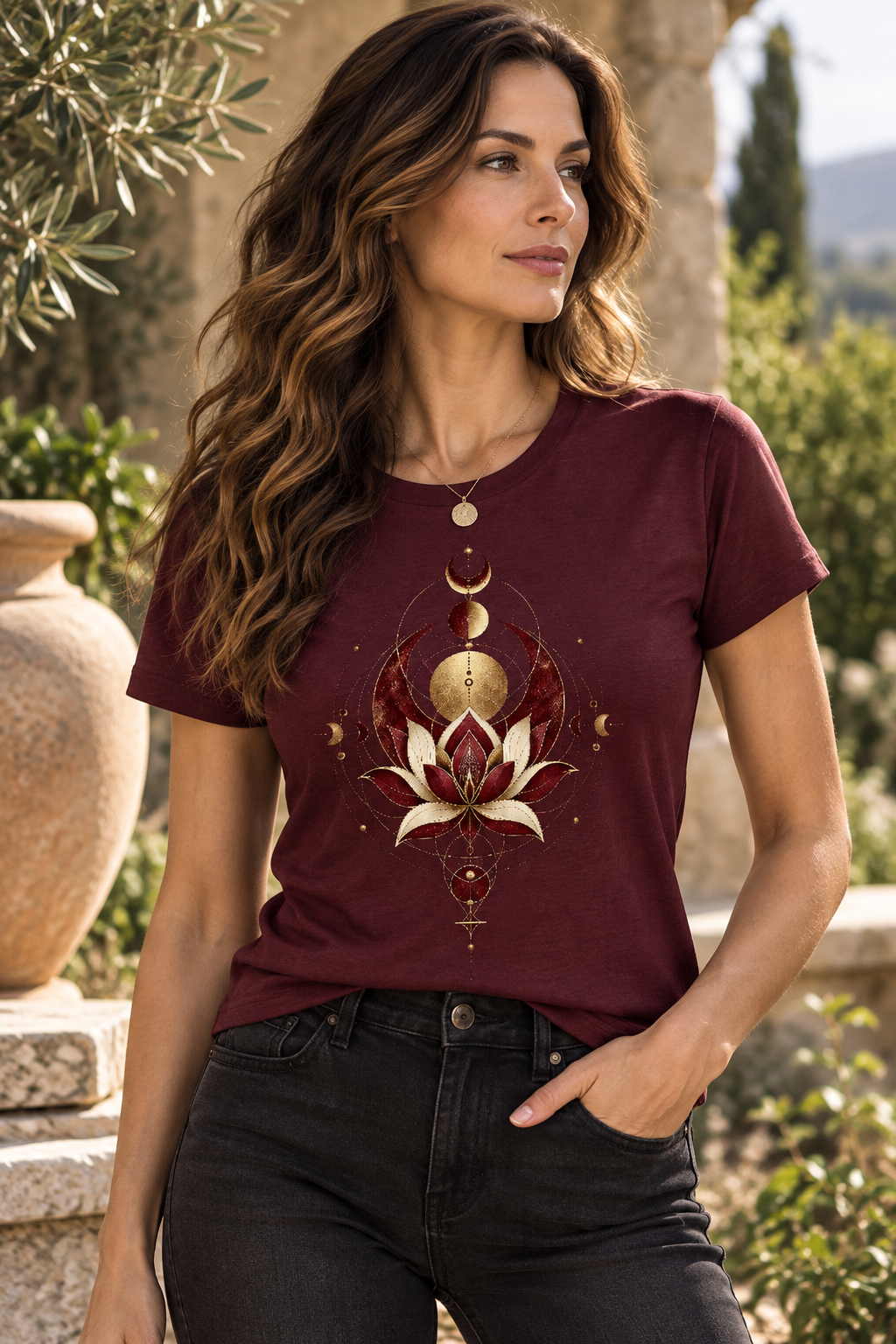 A woman wearing a burgundy Sacred Alignment spiritual graphic T-shirt with lotus, moon phases and celestial geometric artwork in gold and ivory