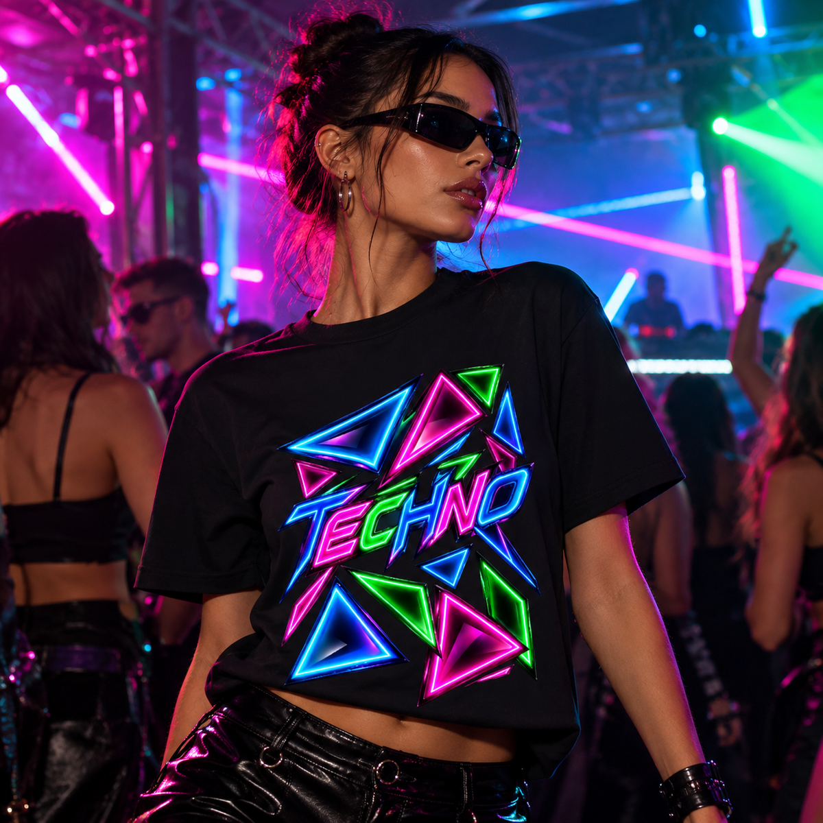 Women wearing a Black women's graphic T-shirt featuring neon blue, pink and green geometric triangles with bold TECHNO lettering by Exalyn Studio.