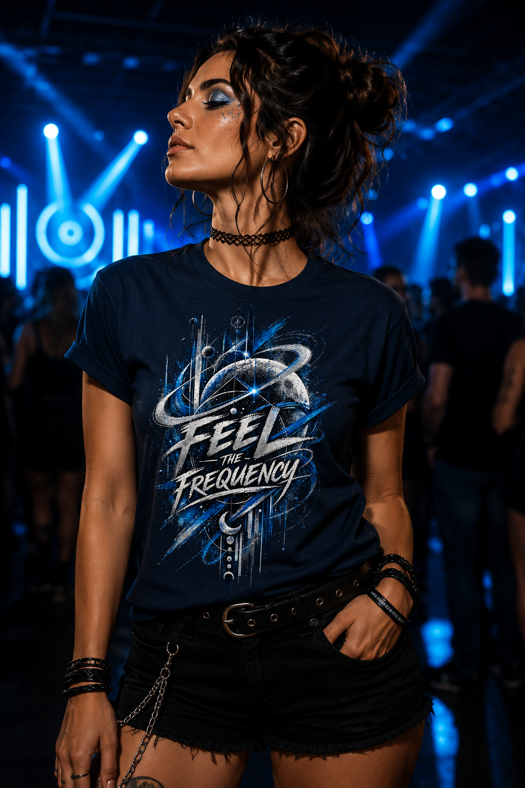 Woman wearing the Feel the Frequency women’s rave graphic T-shirt in dark navy with blue and silver celestial artwork at a techno party.